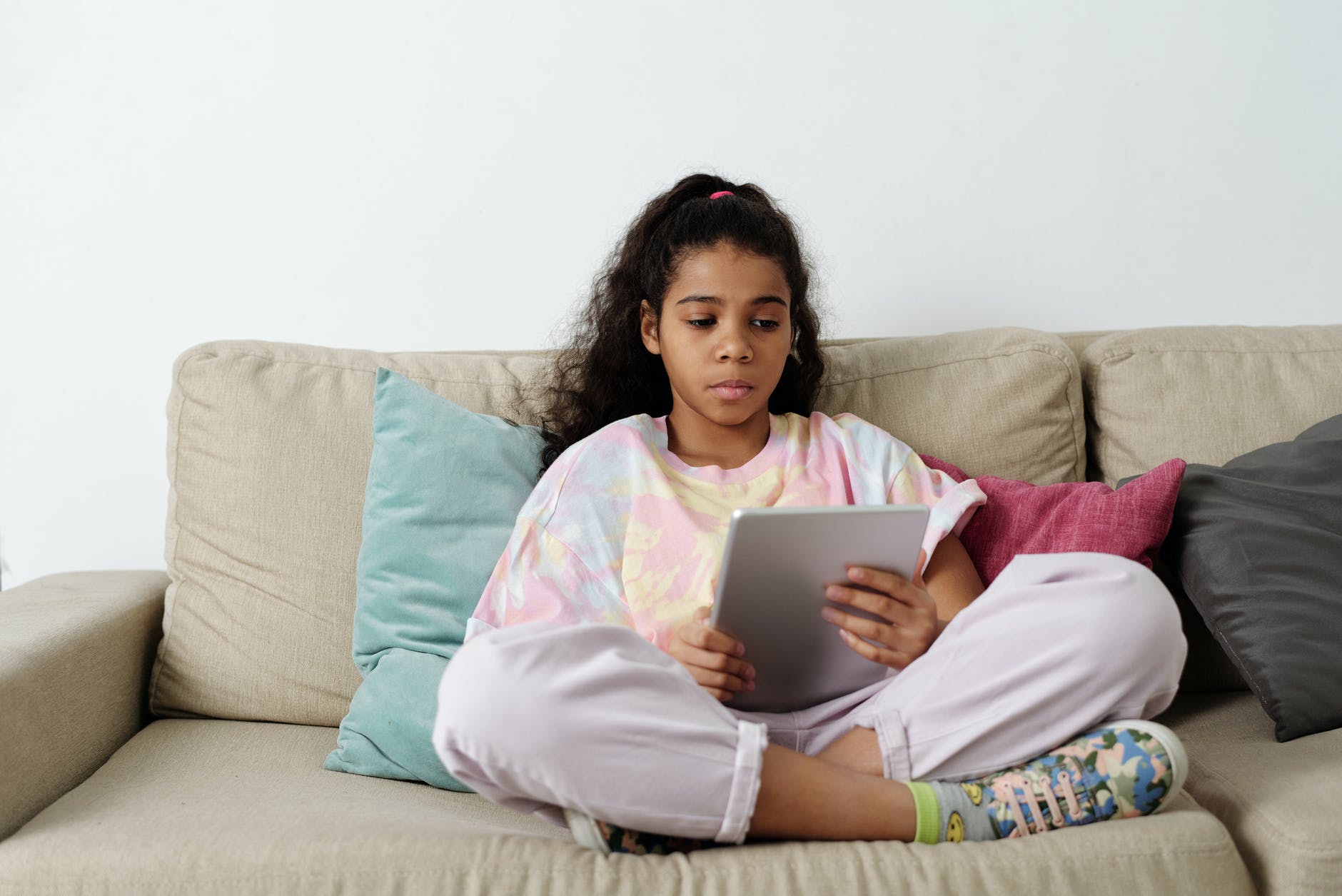 girl in pink shirt sitting on couch